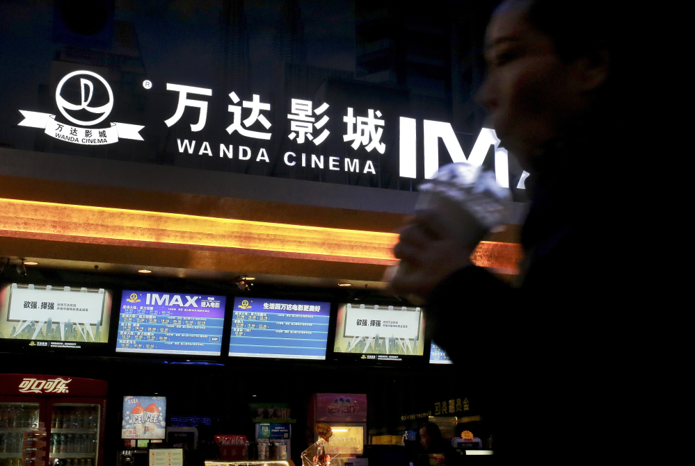 A Chinese moviegoer walks into the Wanda Cinema at the Wanda Group building in Beijing on Tuesday.
