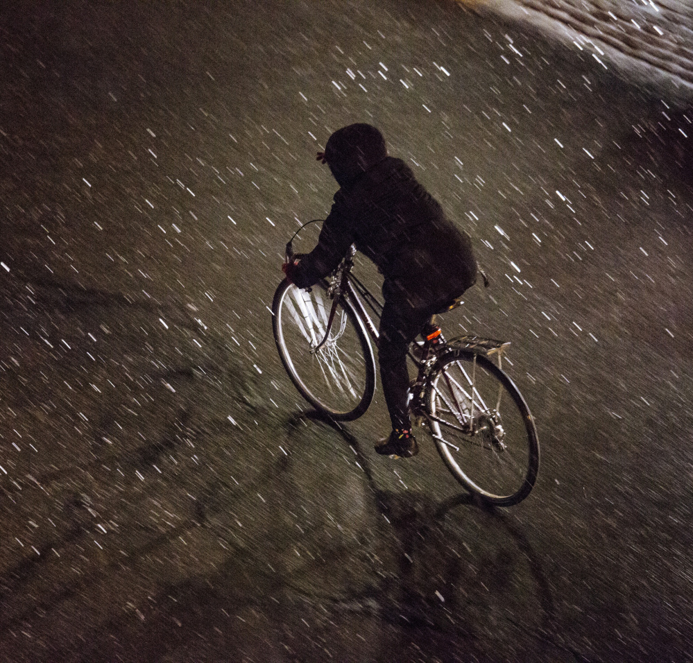PORTLAND, ME - JANUARY 12: A person rides a bike down Free Street as snow begins to fall in Portland, ME on Tuesday, January 12, 2016. (Photo by)