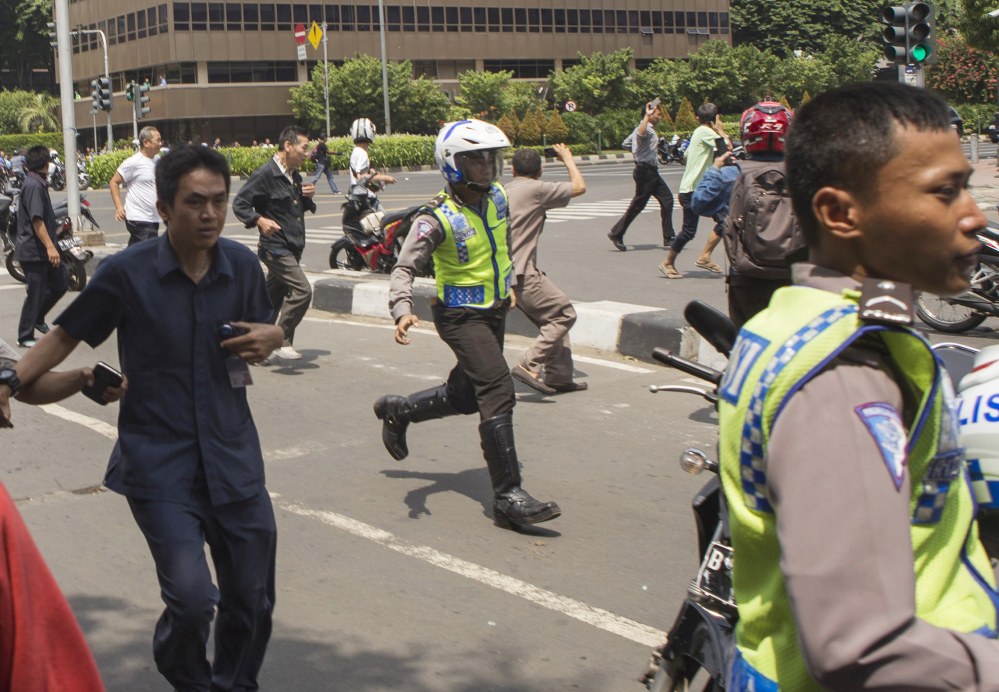 People, including unarmed police officers, flee from a gun battle that broke out following an explosion in Jakarta, Indonesia, on Thursday.
The Associated Press