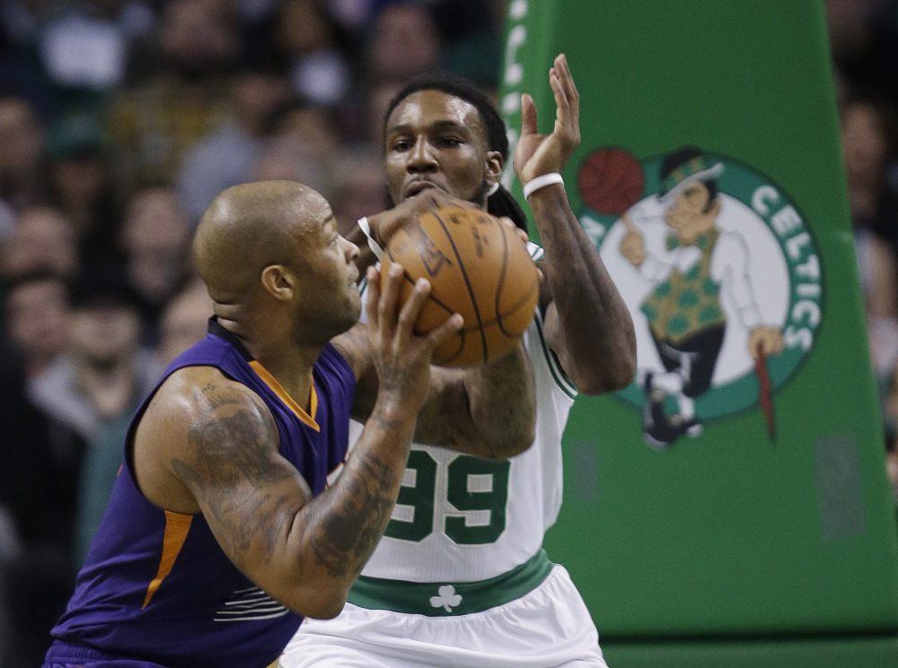 Suns forward P.J. Tucker takes the ball to the hoop against Celtics forward Jae Crowder in the first quarter of Boston’s 117-103 win Friday night in Boston.