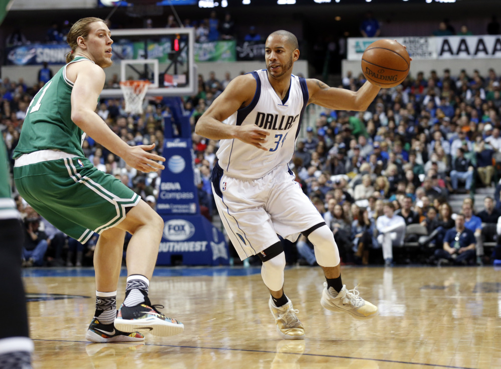 Celtics forward Kelly Olynyk defends against Dallas guard Devin Harris in the first half of a game that went to overtime, with the Mavericks winning after trailing by as many as six points in the fourth quarter.