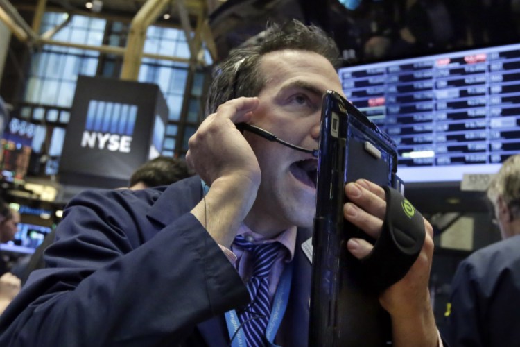 Trader Gregory Rowe works on the floor of the New York Stock Exchange on Wednesday, as energy stocks led another sell-off on Wall Street as the price of oil continued to plunge.