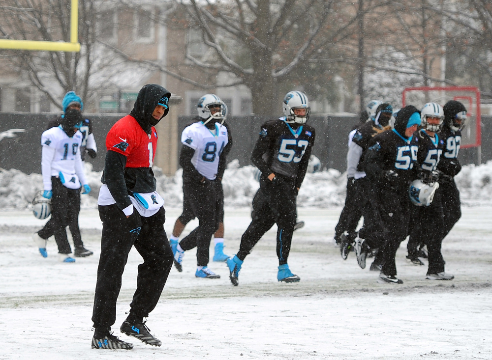 Carolina quarterback Cam Newton, left, and his teammates work out Friday on a practice field covered in snow and ice as they prepare for Sunday’s NFC championship game.