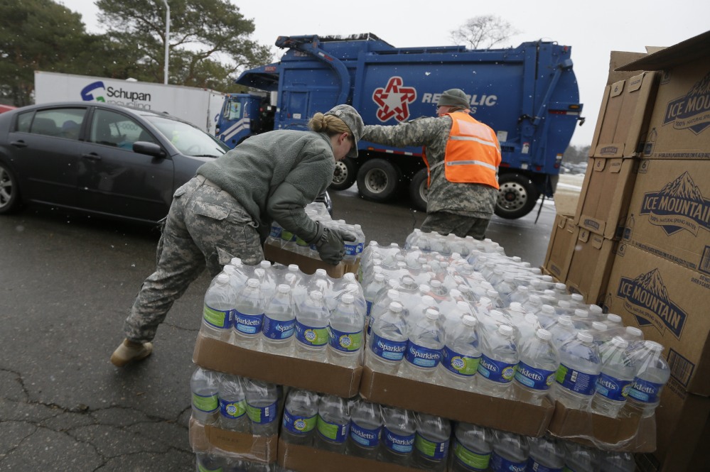 Members of the Michigan National Guard load bottled water at a fire station Thursday in Flint, Mich., where the municipal water supply is contaminated with lead.