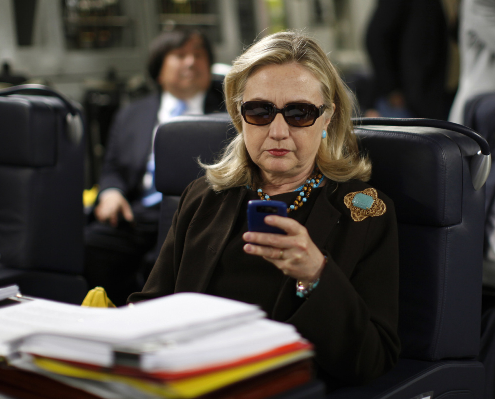 Then-Secretary of State Hillary Rodham Clinton checks her Blackberry from a desk inside a C-17 military plane. The Obama administration said Friday for the first time that Clinton’s unsecured home server contained some closely guarded secrets.