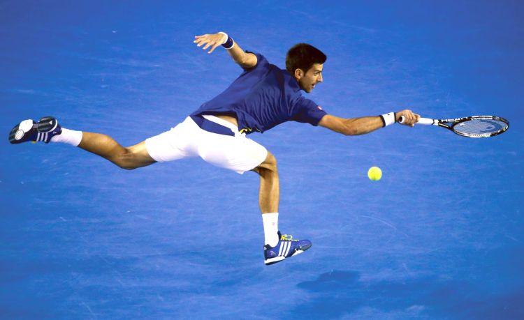 Novak Djokovic lunges to  return a volley during his semifinal match with Roger Federer at the Australian Open tennis championships in Melbourne, Australia, Thursday. The Associated Press
