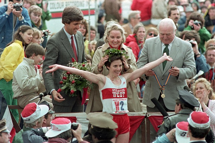  Joan Benoit receives her laurel wreath and reacts to cheering crowds after winning the Boston Marathon in record time for the women's division in this April 19, 1983,  photo. Then-Massachusetts Lt. Gov. John Kerry, in red tie, stands behind her. Benoit also won the women's division of the race in 1979. The Associated Press