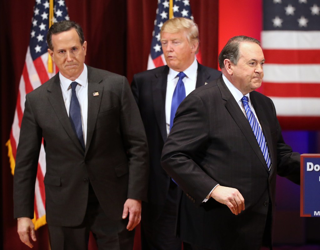 Donald Trump appears on stage with Republican candidates Rick Santorum, left, and Mike Huckabee at Trump's event Thursday night. Santorum and Huckabee had participated earlier Thursday night in the preliminary Republican debate in Des Moines.