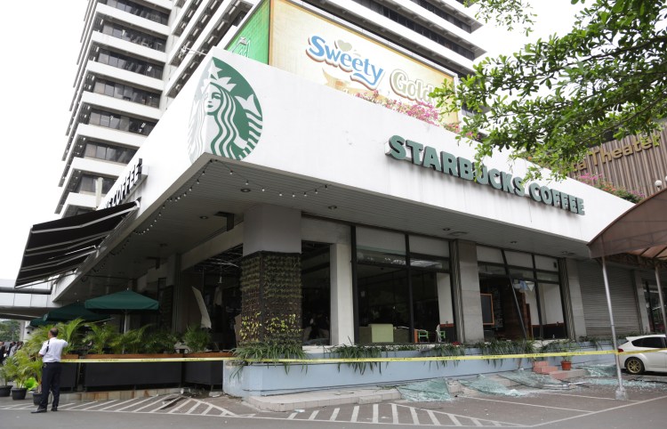 A damaged Starbucks cafe is cordoned off after an attack in Jakarta, Indonesia on Thursday. Attackers set off explosions at the cafe in a bustling shopping area in Indonesia's capital. The Associated Press