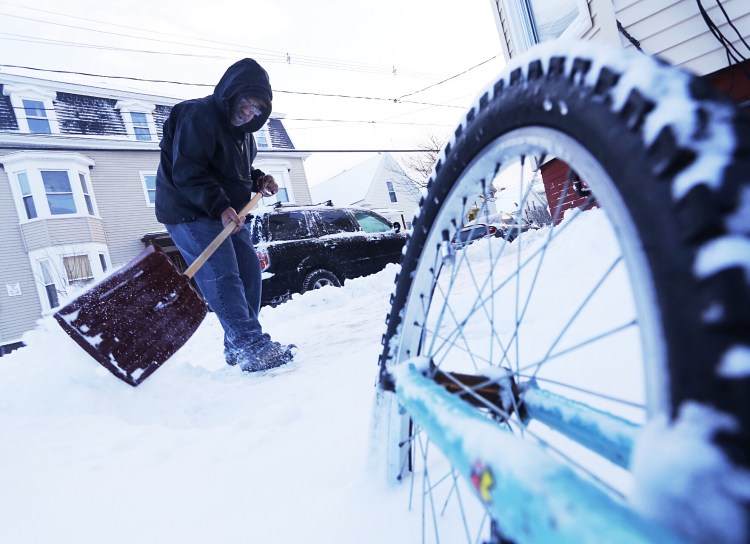 Harrison Rice shovels the sidewalk outside his Portland residence on Wednesday after an overnight storm left several inches of fresh snow. Derek Davis/ Staff Photographer
