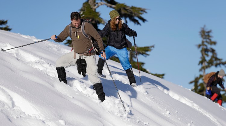 Steve Udd, a parent of a student in an avalanche program, and Gwyneth Lyman, 16, send small roller balls of snow ahead of them as they navigate a steep slope on snowshoes during an avalanche awareness field trip for teenagers at Mount Baker, Wash. 