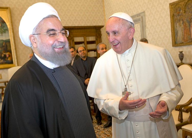 Pope Francis and Iranian President Hassan Rouhani share a laugh during their private audience at the Vatican, Tuesday. Iran’s president is visiting European leaders with the aim of  positioning Tehran as a potential broker in efforts to resolve Middle East conflicts, including Syria’s civil war. The Associated Press
