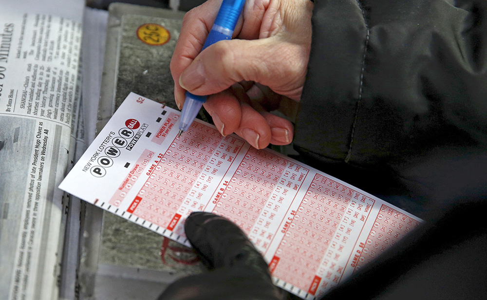 A woman fills out a ticket for the Powerball lottery in Times Square Thursday. Reuters