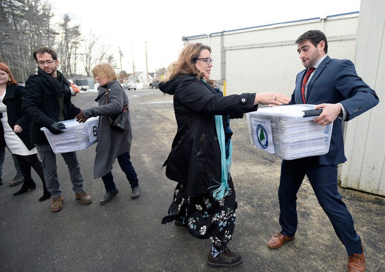 Campaign manager David Boyer passes a box of petitions to Rep. Diane Russell  from Portland as the Campaign to Regulate Marijuana Like Alcohol prepares to deliver the petitions to Augusta Monday, February 1, 2016. 