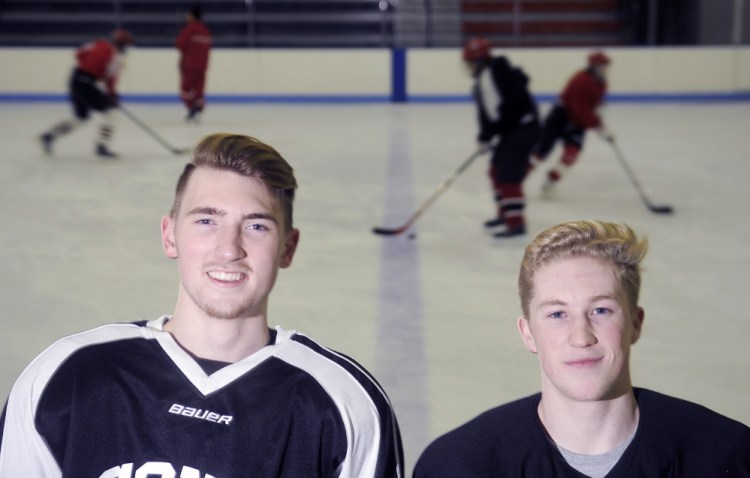 Cony High School hockey players Riley Boivin, left, and Connor Perry pose at the Ice Vault in Hallowell on Monday.