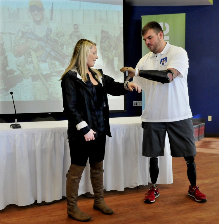 Travis Mills explains the use of his prosthetic devices to Thomas College Student Amanda Landry. Mills was the opening keynote speaker at the college’s fourth annual Diversity Conference Tuesday.