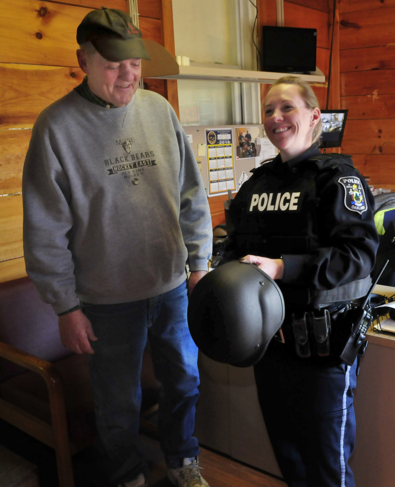 Oakland police officer Tanya Allen on Tuesday tries on one of four new ballistic vests and helmets that were donated to the department by area businessmen in the wake of the fatal shooting in town last November. The donors are Kevin Joseph, E. J. Fabian and Dave Libby, seen beside Allen.