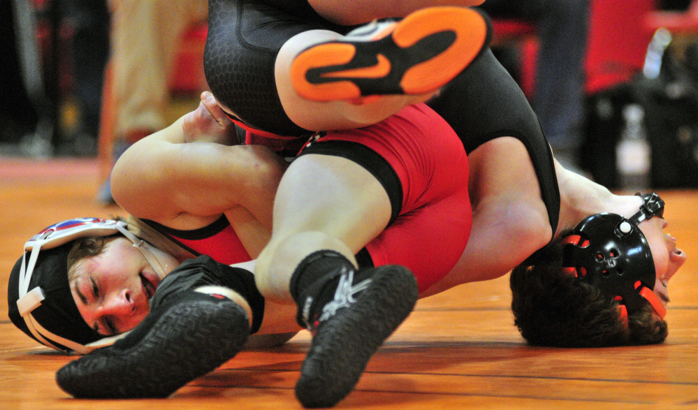 Cony’s Noah Dumas, left, and Skowhegan’s Austin Merrill compete in the semifinals of the 106-pound class during the Kennebec Valley Athletic Conference wrestling championships last Saturday afternoon at Cony High School. Dumas won the match and would go on to take the title.