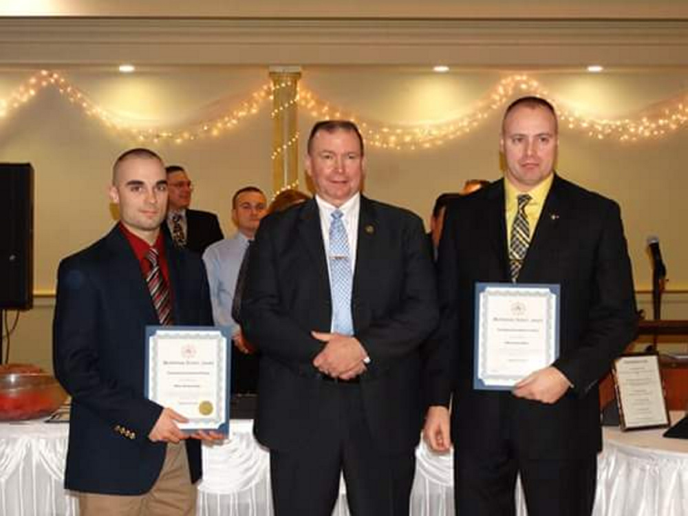 Farmington police officers Michael Lyman, left, and Darin Gilbert, right, receive a Meritorious Service Award from Maine Association of Police President Kevin Riordan, center, at the MAP awards banquet last week. The two Farmington officers were recognized for helping to find a missing New Hampshire boy who was allegedly abducted by his father in July.