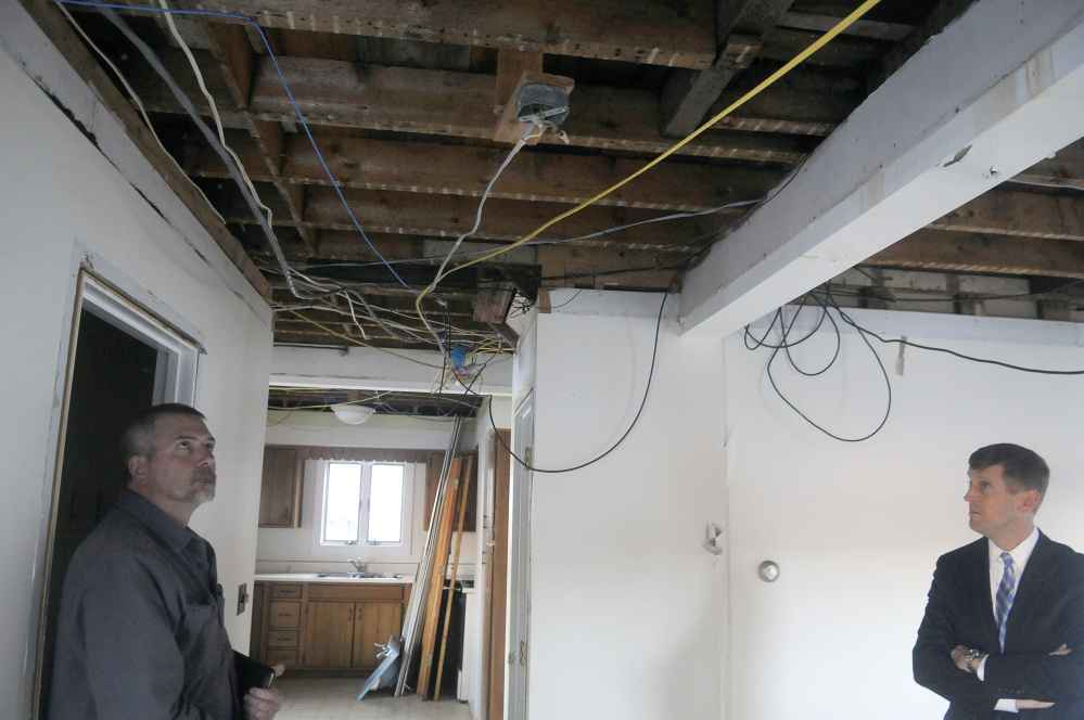 Contractor Andrew Beaulieu, left, and attorney Walt McKee examine the water damaged interior of 226 Water St. in Hallowell on Tuesday, a building developer Steve Hammond wants to demolish.