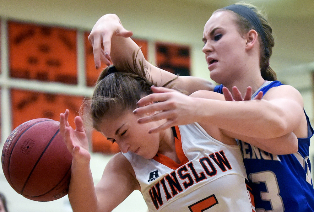 Winslow’s Brogan Gagnon, front, and Lawrence’s Nia Irving battle for a rebound during a Kennebec Valley Athletic Conference game earlier this season.