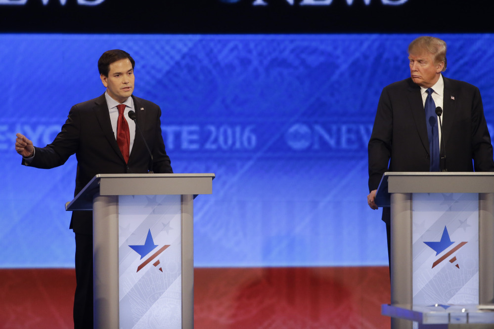 Republican presidential candidate, Sen. Marco Rubio, R-Fla., answers a question as Republican presidential candidate, businessman Donald Trump listens during a Republican presidential primary debate hosted by ABC News at the St. Anselm College  Saturday in Manchester, N.H.