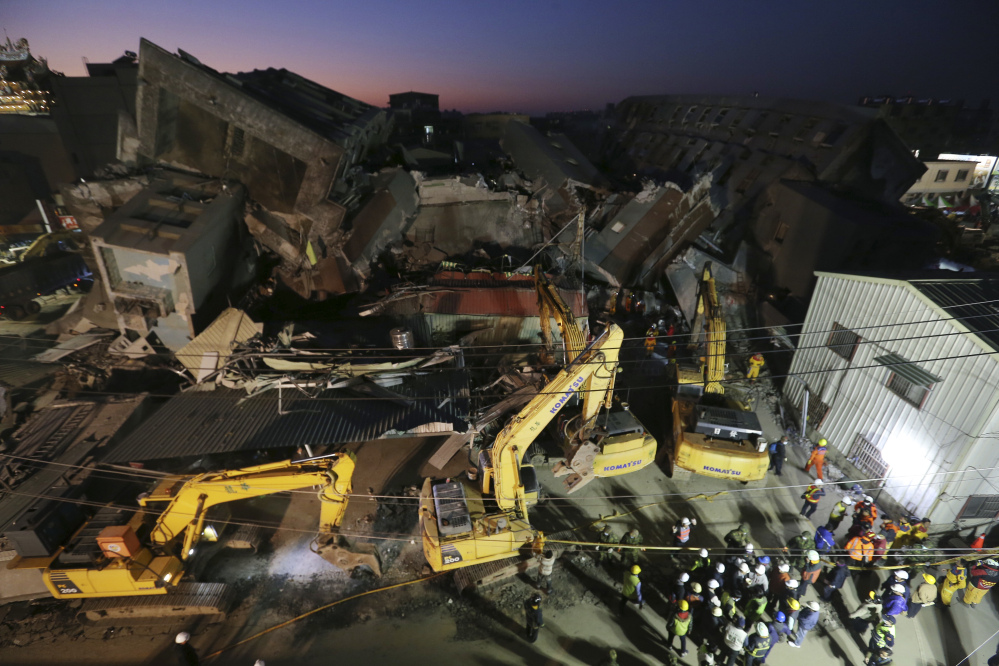As night falls, emergency rescue workers continue to search the rubble of a collapsed building complex in Tainan, Taiwan, Monday.