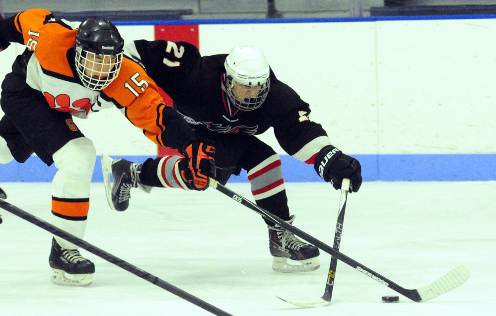 Gardiner forward Logan Peacock, left, and Maranacook/Winthrop’s Danny Shea chase down a puck during a game earlier this season at the Ice Vault in Hallowell. Peacock and the Tigers are playoff-bound.
