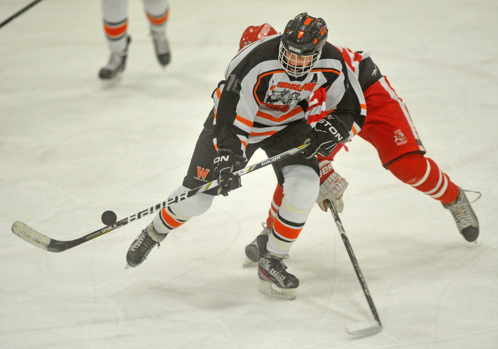 Winslow forward Jacob Trask, front, battles for the puck with a Cony defender during a game last season at Sukee Arena. The Black Raiders edged Messalonskee in overtime last Saturday.