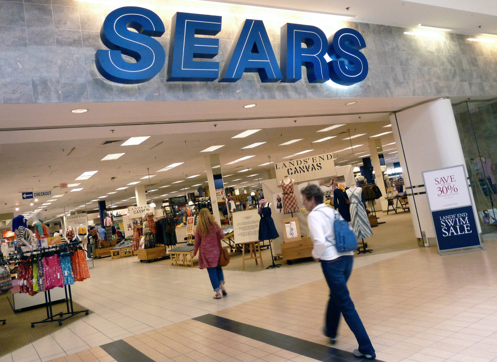 In this May 14, 2012 file photo, shoppers walk into Sears in Peabody, Mass. After a “challenging” holiday shopping season, Sears is accelerating the closing of some of its stores.