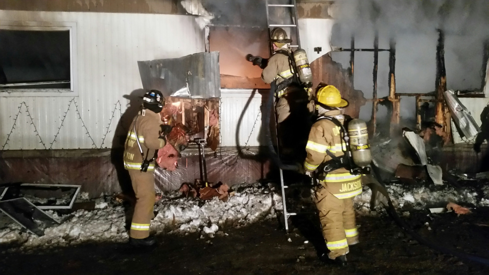 Firefighters hose down a mobile home that erupted in flames early Saturday morning on Webb Road in Oakland.