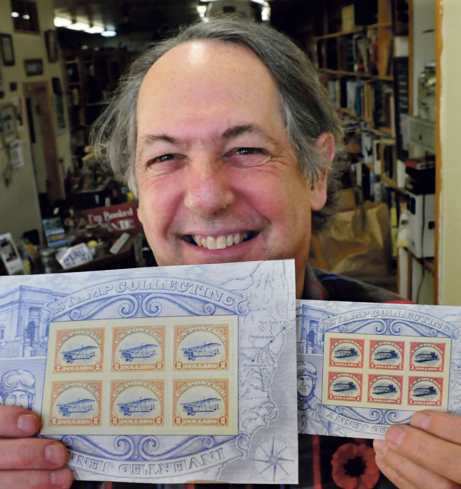 Robert Sezak holds copies of two versions of postage stamps on Nov. 9. The copies at left show a Jenny aircraft in the upright flying position, which fetched $50,000 when auctioned at Julia’s Auctions in Fairfield recently. In the 2.2 million-stamp run, 100 of the upright Jenny were included.