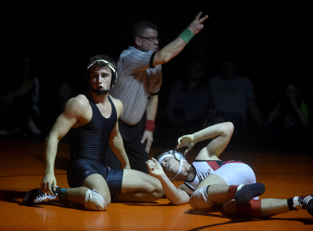 Skowhegan Area High School’s Kameron Sirois, left, receives two points against Camden Hills High School’s Eli Smith, right, in the 160-pound class in the regional finals Saturday in Skowhegan.