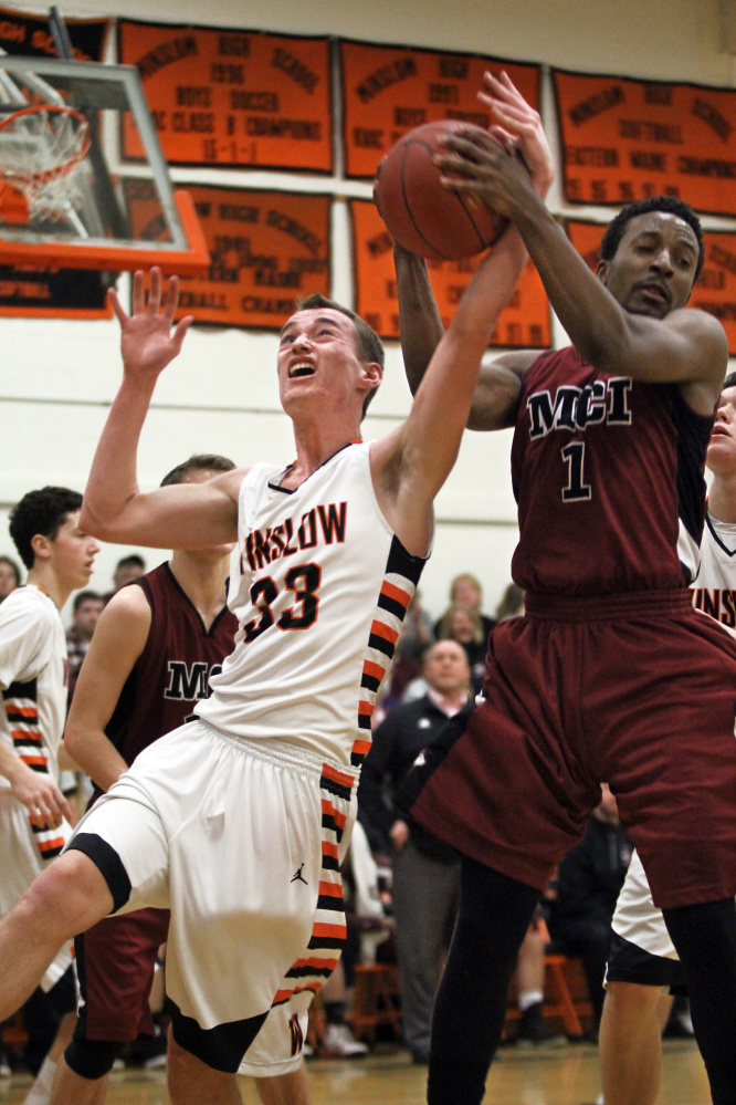 Winslow High School’s Justin Burgher (33) battles for a rebound with Maine Central Institute’s Tre Grier during the first half of a Class B North preliminary playoff game Wednesday in Winslow. MCI won and will head to Bangor on Saturday to play Ellsworth in a regional quarterfinal round game at 9:05 a.m.