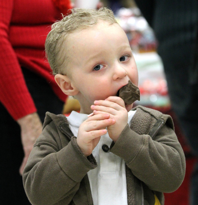 Eli Dulac, 2, of Clinton, takes a bite of a chocolate lollipop Saturday at the annual Fairfield Chocolate Festival. The event, held in the Fairfield Community Center, raised money for the Fairfield Council of Churches Emergency Heating Fund.