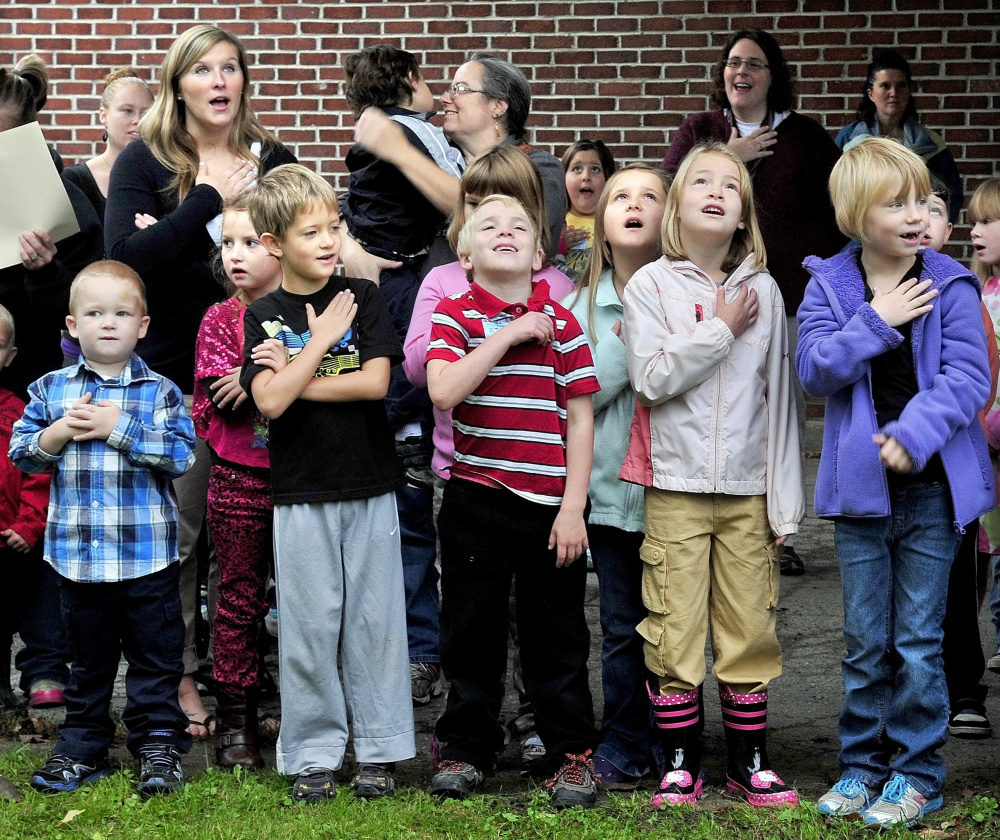 Students salute the flag in 2012 at the opening of Cornville Regional Charter School. The school has changed its bylaws so that its board is appointed, rather than elected.