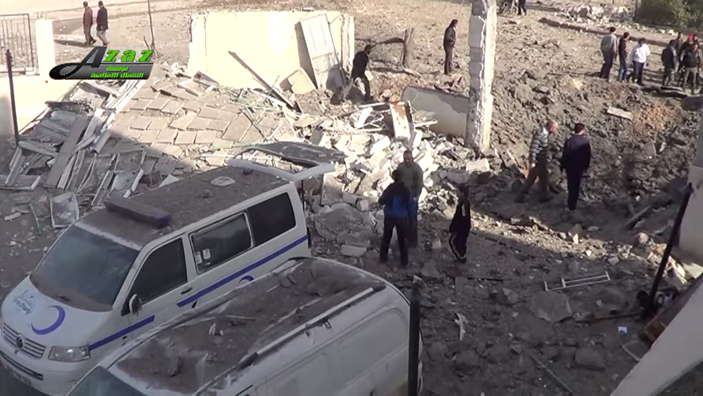 This image taken from video provided by the Syrian activist-based media group Azaz Media Center, which has-been verified and is consistent with other AP reporting, shows people gathered around destroyed vehicles in Azaz, Syria Syria, Monday.