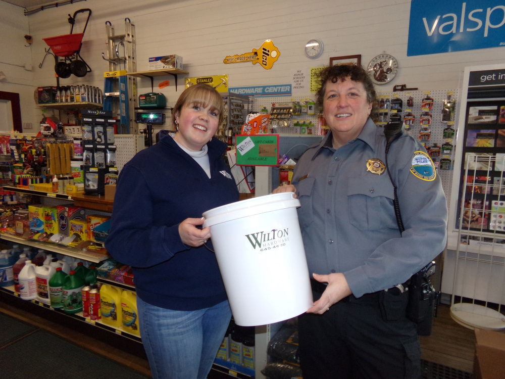 Chief Heidi Wilcox accepts a donated bucket from Wilton Hardware Store’s owner, Jessie Sawyer.