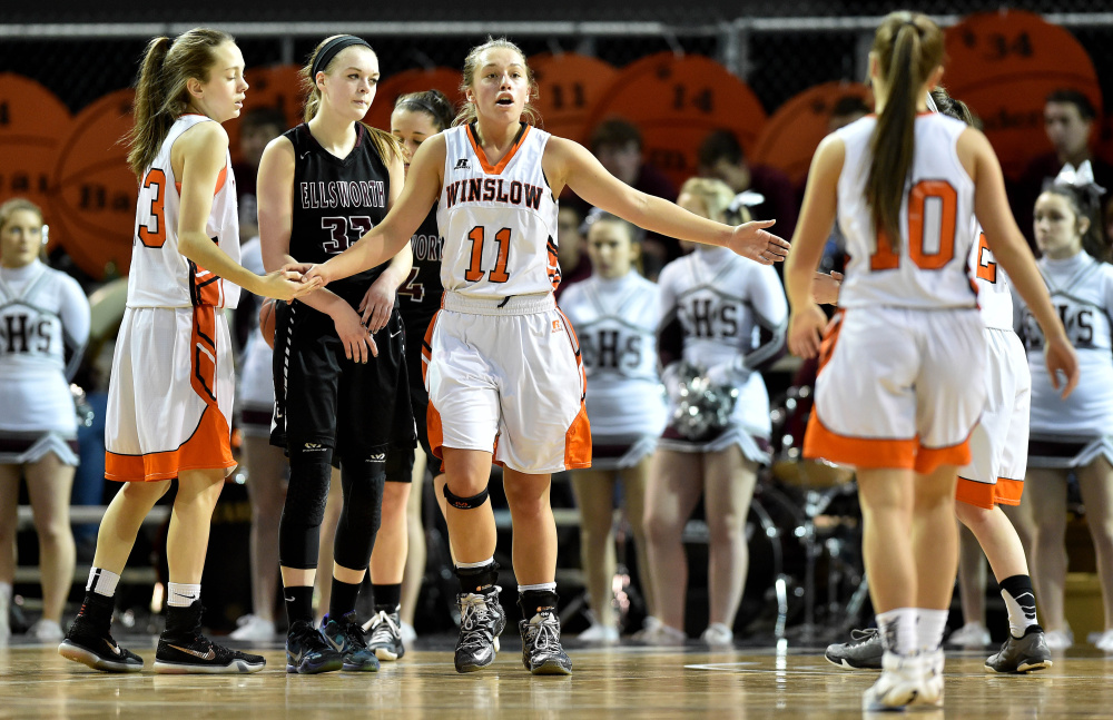 Winslow’s Heather Kervin (11) high-fives teammates after getting fouled in a Class B North quarterfinal against Ellsworth at the Cross Insurance Center in Bangor on Saturday.