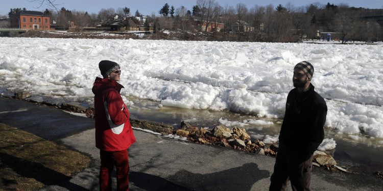 Amber Whittaker, left, and Ryan Gordon of the Maine Geological Survey examine Wednesday the ice jam on the Kennebec River in Augusta. Gordon, a hydrogeologist, said flooding occurs annually along the river corridor.