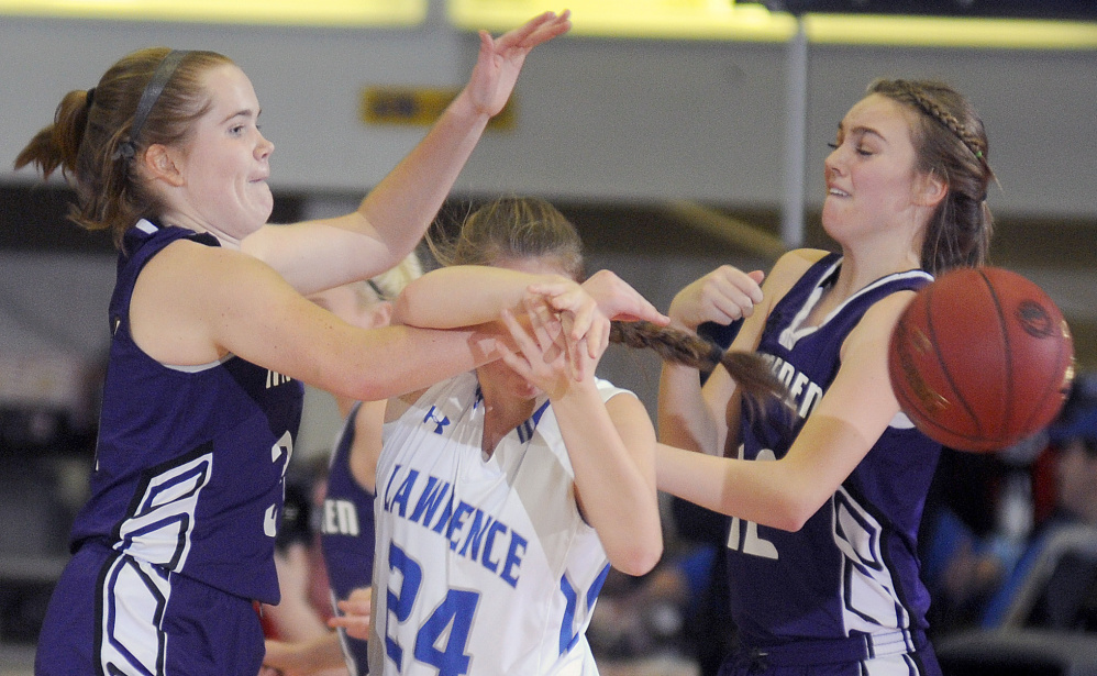 Lawrence’s Molly Folsom draws heavy pressure from Hampden Academy’s Peyton Smith, right, and Courtney Dunton during a Class A North semifinal Wednesday night at the Augusta Civic Center.