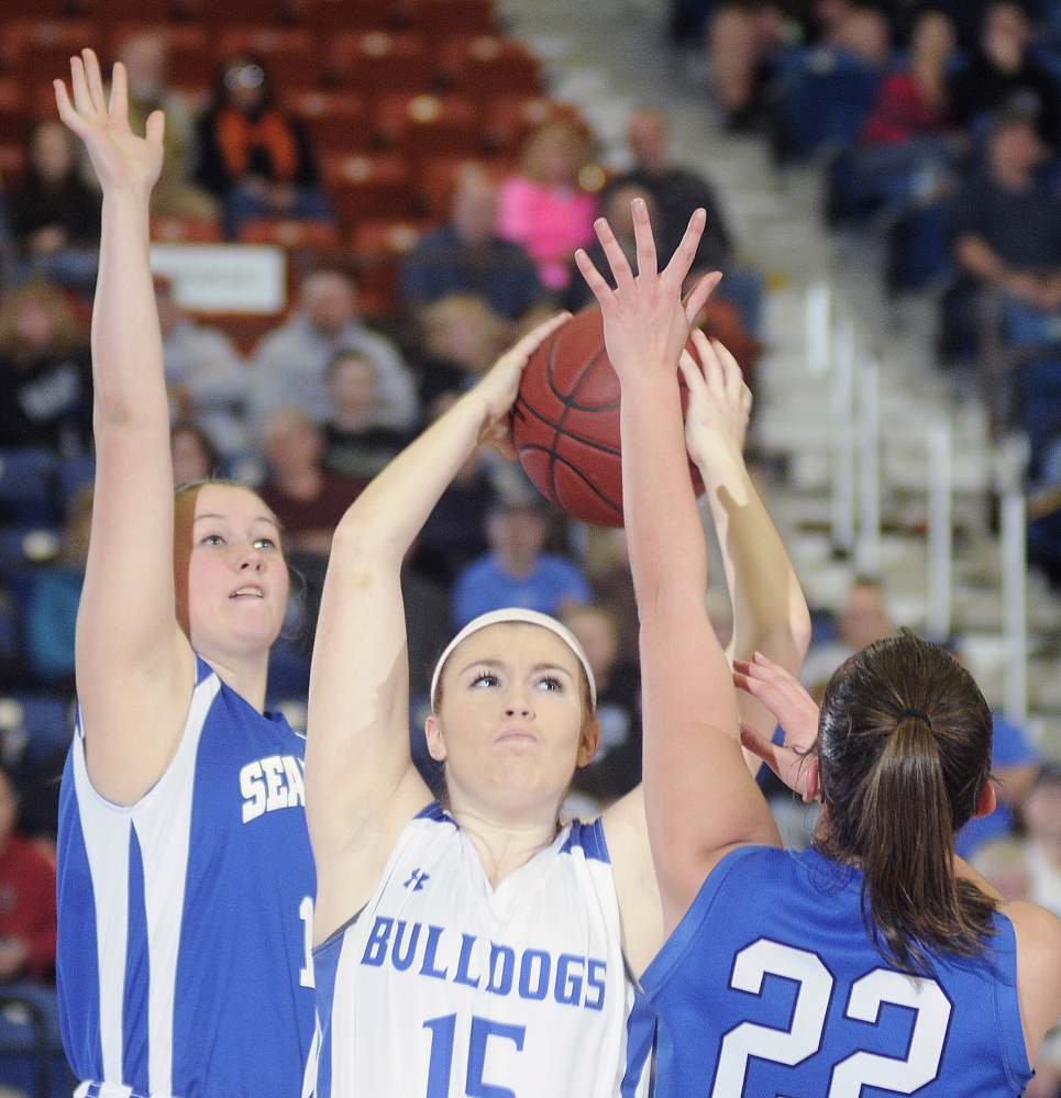 Madison Area Memorial High School’s Lauren Hay grabs a rebound between Searsport District High School’s Arianna Stemp, left, and Anna Bucklin during a Class C South semifinal game Thursday in Augusta.