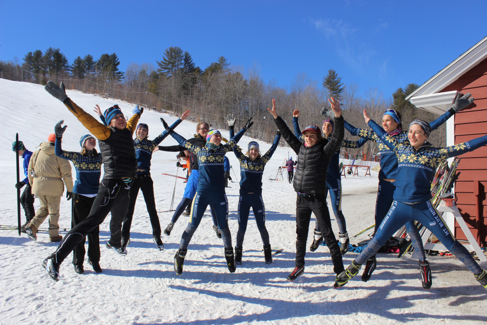 Mt. Blue coach Claire Polfus, assistant coach Patty Veayo and members of the Mt. Blue Nordic ski team celebrate their Class A state championship Friday at Titcomb Mountain.