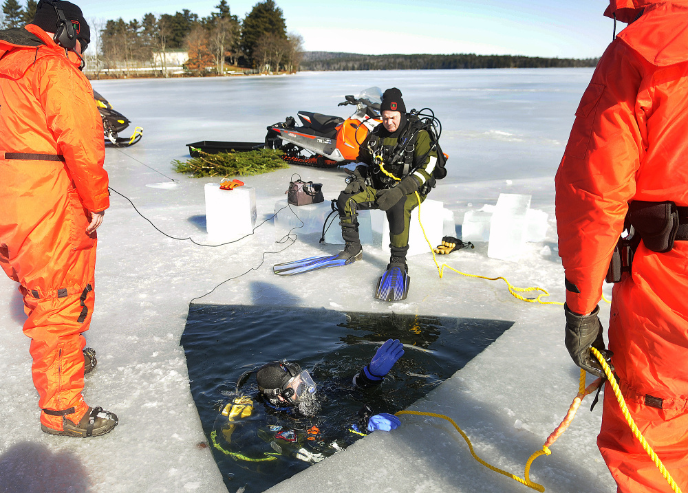 Warden Ethan Buuck and other members of the Maine Warden Service dive team work to recover the body of Derek Palange, who was reported missing from Belgrade Jan. 11.