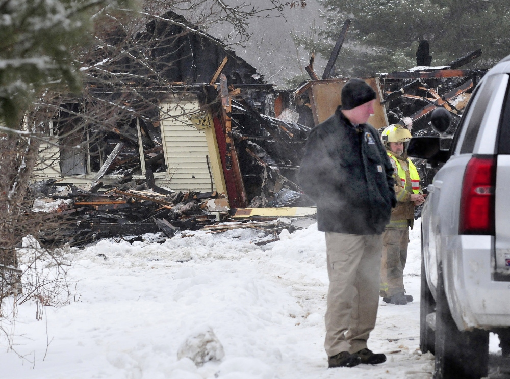 Sgt. Ken Grimes of the state fire marshal’s office speaks with another investigator outside a home on Pease Hill Road in Anson that was destroyed by fire early Wednesday morning.