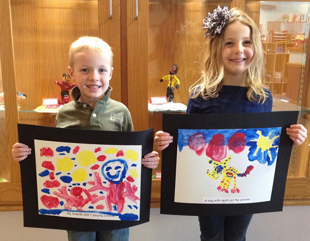 Cape Cod Hill School kindergarten students Bailey Markham, left, and Emily Coffey display their “sentence paintings with tempura.” The art will be part of a display at the Youth Art Month show at Upcountry Artists Gallery in Farmington.