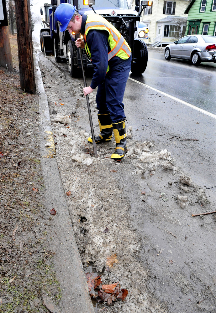 Josh Berryman of the Skowhegan Highway Department and other employees kept busy keeping drains open along roads left clogged with ice, slush and leaves from the heavy rains early Thursday.
