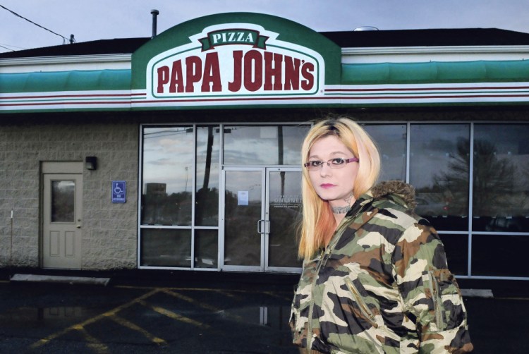 Papa John’s restaurant manager Theresa Ratliff stands outside the closed business Thursday in Waterville.