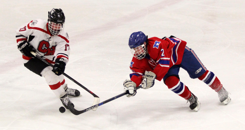 Messalonskee High School’s Dana Michaud battles for the puck with Camden’s Kieren Lydon during the Eagles’ 3-1 victory in a Class B North semifinal at Sukee Arena in Winslow on Saturday night.