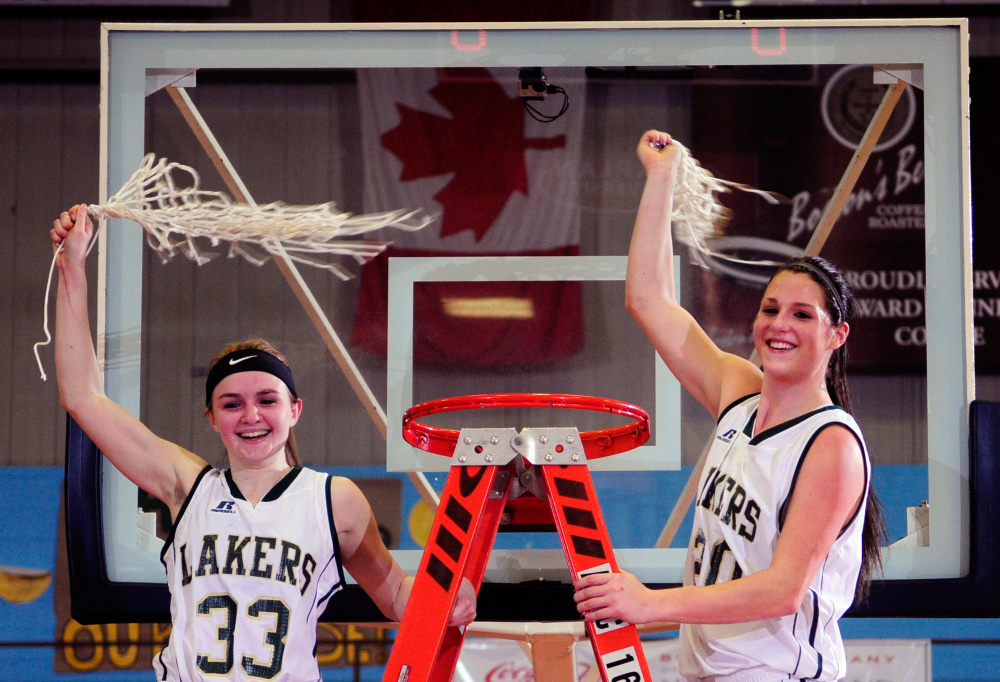 Rangeley’s Maddison Egan, left, and Blayke Morin celebrate with freshly trimmed nets after the Lakers sank Shead in the Class D state championship game Saturday at Augusta Civic Center.